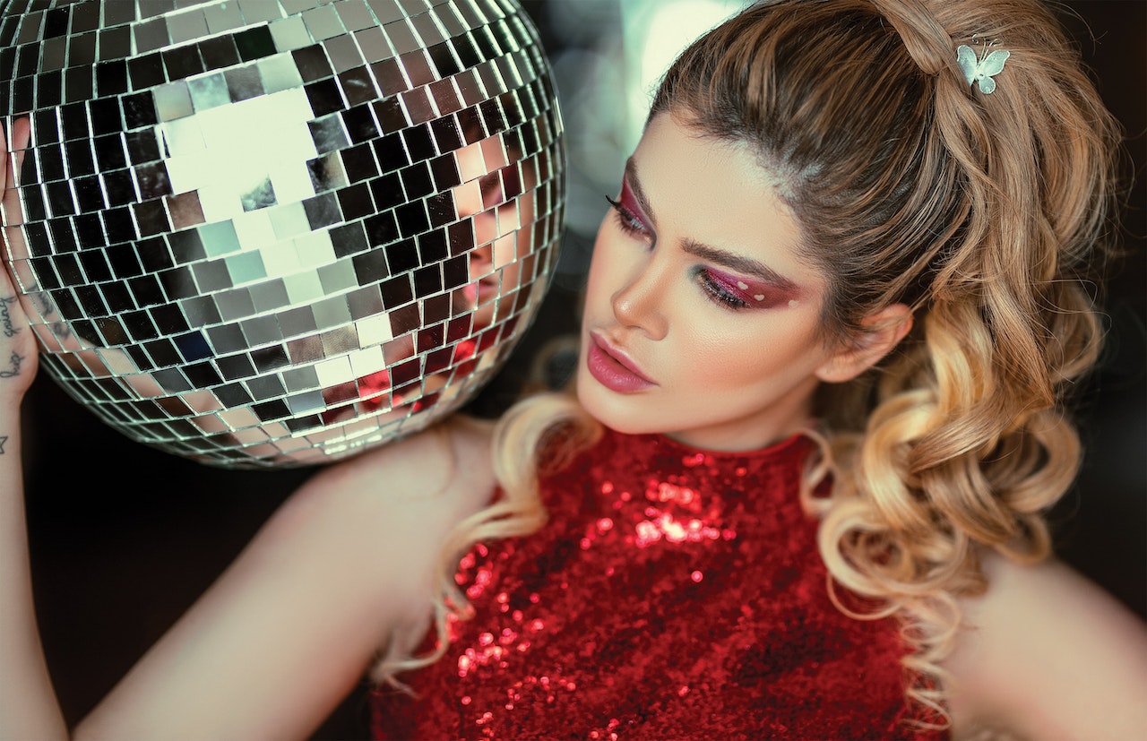 Photo by Ali Pazani: https://www.pexels.com/photo/photo-of-a-woman-in-red-glitter-halter-top-holding-disco-ball-2584261/