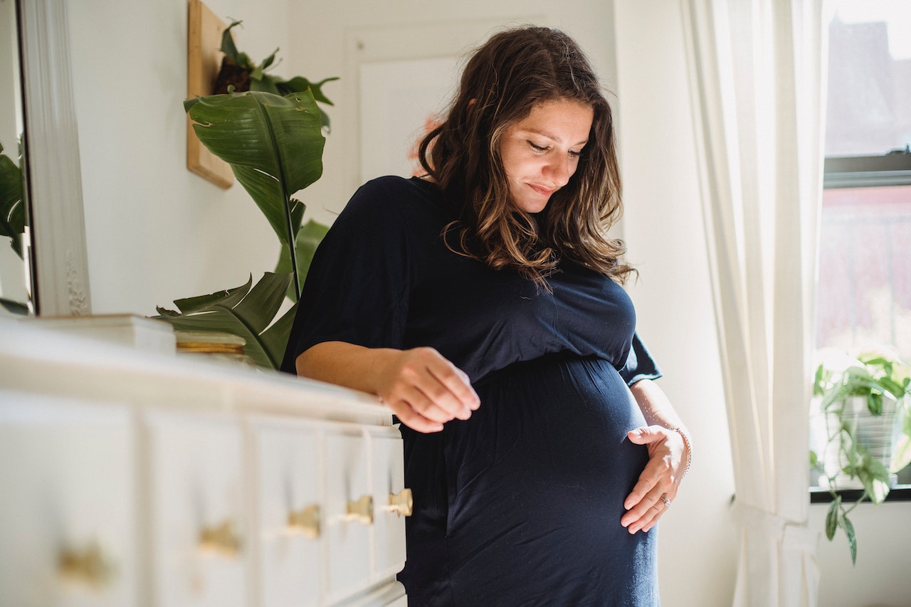 Photo by Amina Filkins: https://www.pexels.com/photo/smiling-pregnant-woman-caressing-tummy-in-house-room-5427247/